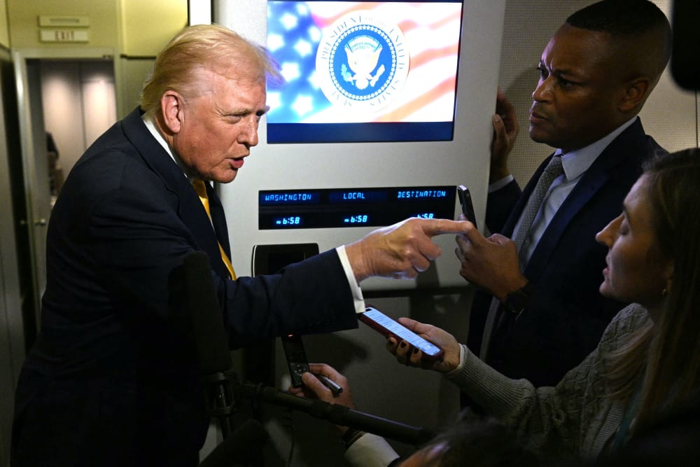 U.S. President Donald Trump speaks to reporters aboard Air Force One.