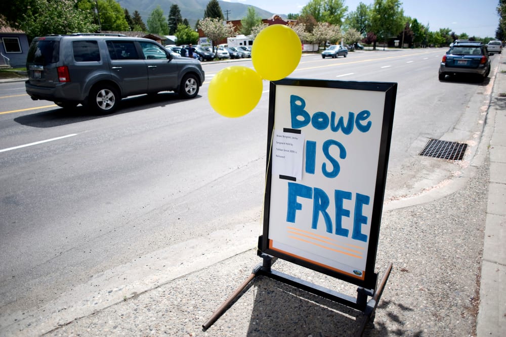 A car drives past yellow balloons and a sign of support for U.S. Army Sergeant Bergdahl in Hailey, Idaho