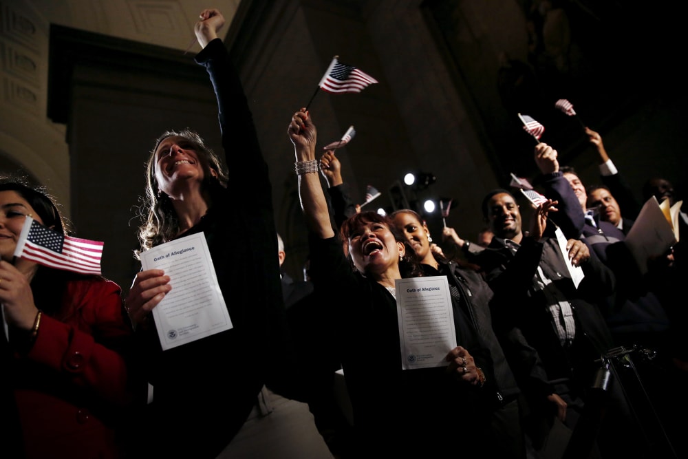 People celebrate as they become U.S. citizens during a naturalization ceremony at the National Archives Museum in Washington, Dec. 15, 2015. (Photo by Carlos Barria/Reuters)