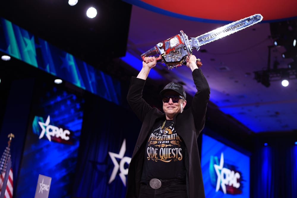 Elon Musk leaves the stage holding a chainsaw after speaking at the Conservative Political Action Conference in Oxon Hill, M.D., on Feb. 20, 2025.