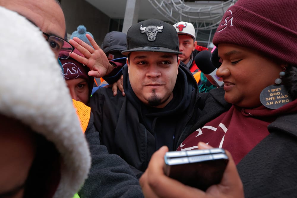 Kilmar Abrego Garcia surrounded by people at the U.S. Immigration and Customs Enforcement Baltimore Field Office.