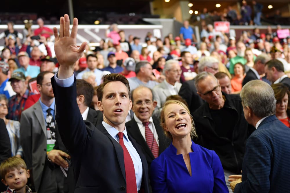 Then Missouri Attorney General Josh Hawley, left, and his wife Erin Morrow Hawley wave at a rally in Springfield, MO