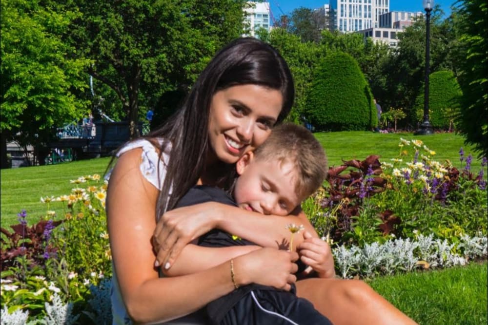Bruna Ferreira and hugging her young son in a park