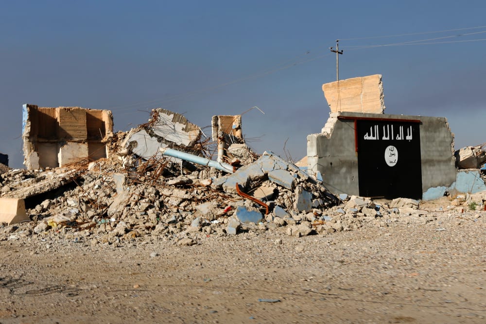 A destroyed building with a wall painted with the black flag commonly used by Islamic State militants is seen, March 10, 2015. (Photo by Thaier Al-Sudani/Reuters)
