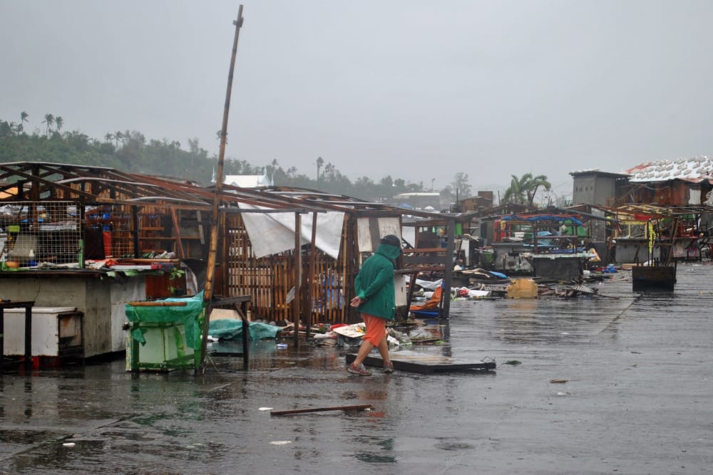 A man walks past destroyed houses in Tacloban, central Philippines, on Dec. 7, 2014 after Typhoon Hagupit. (Lito Bagunas/AFP/Getty)