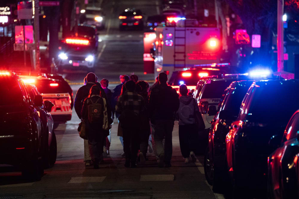 Emergency personnel escort students from one of the buildings of Brown University in Providence, Rhode Island, on Dec.13, 2025.