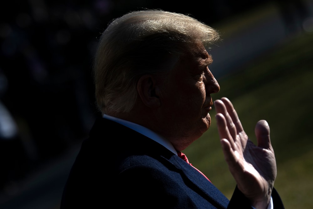 President Donald Trump puts his hand up on the South Lawn of the White House on Jan. 12, 2021.