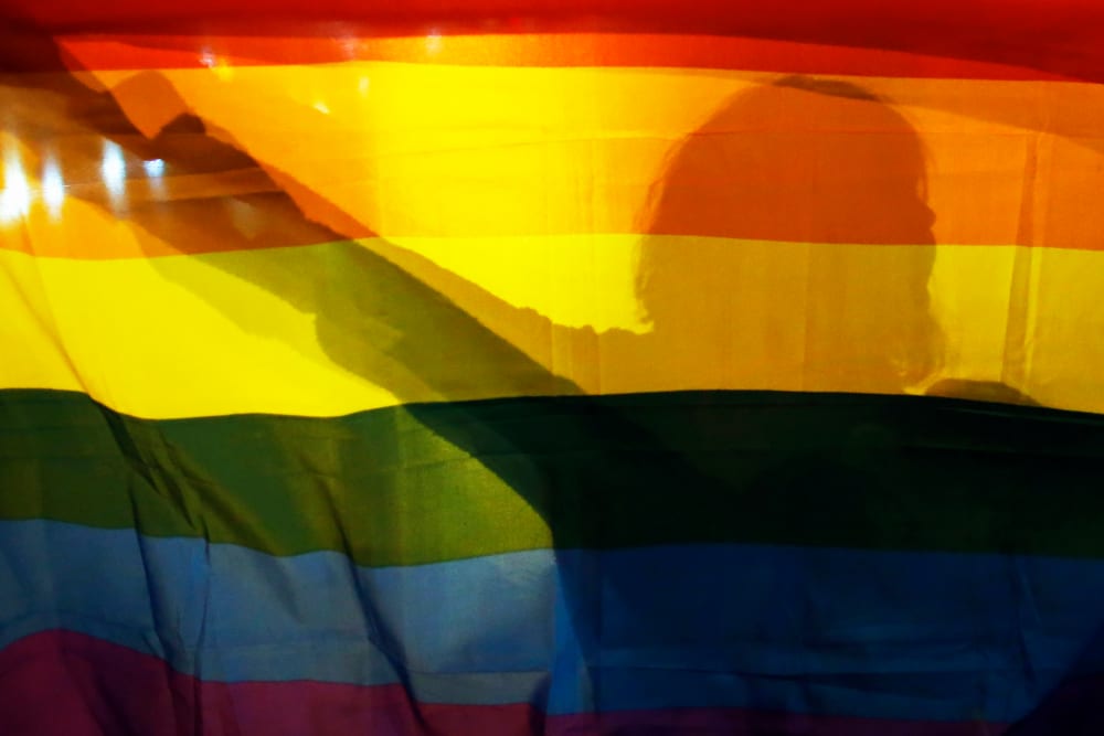 A gay rights activist holds a rainbow flag. (Photo by Marko Djurica/Reuters)