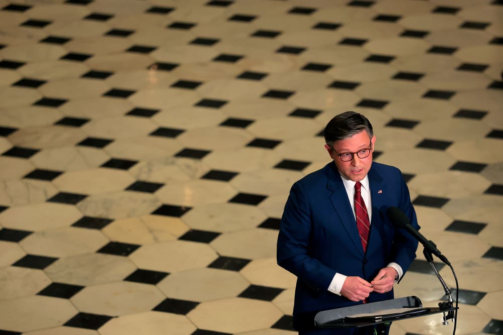 An aerial view of Speaker of the House Mike Johnson as he holds a news conference surrounded by the checkered floor of the Capitol.