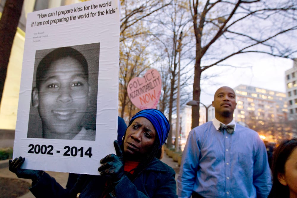 In a Monday, Dec. 1, 2014 file photo, Tomiko Shine holds up a picture of Tamir Rice, the 12 year old boy fatally shot on Nov. 22 by a rookie police officer, in Cleveland, Ohio, during a protest. (Photo by Jose Luis Magana/AP)