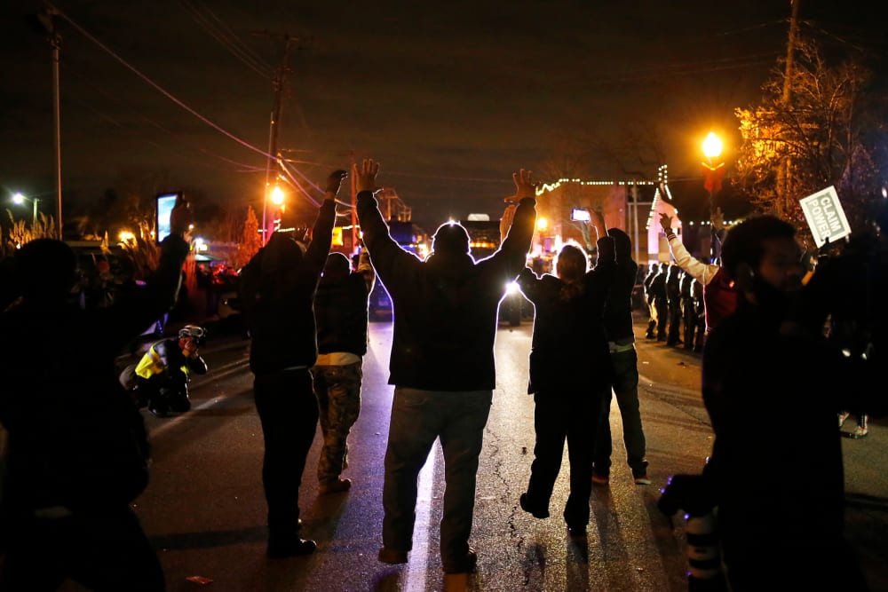 Protesters approach a police line with their hands up after a grand jury returned no indictment in the shooting of Michael Brown in Ferguson, Mo. on Nov. 24, 2014. (Photo by Adrees Latif/Reuters)