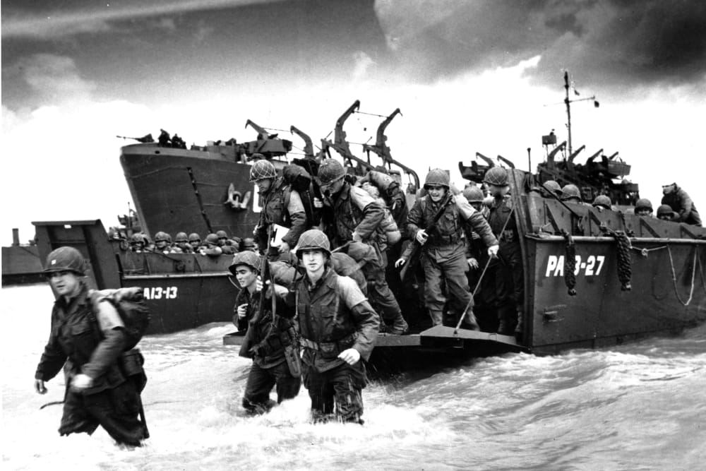 American reinforcements arrive on the beaches of Normandy from a Coast Guard landing barge into the surf on the French coast on June 23, 1944 during World War II.