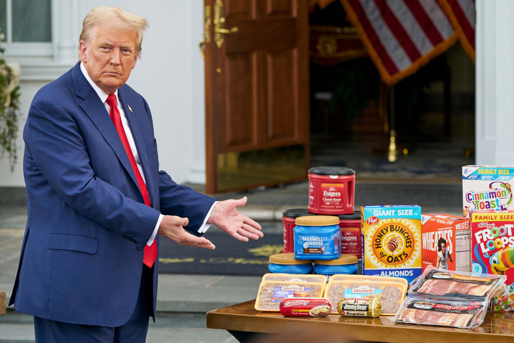 President Donald Trump gestures toward a table of groceries during a news conference.
