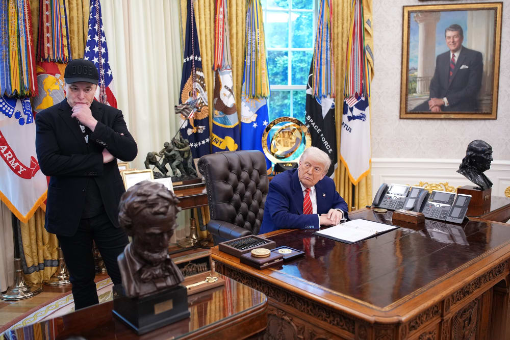 Tesla CEO Elon Musk and U.S. President Donald Trump listen to a question from reporters in the Oval Office.