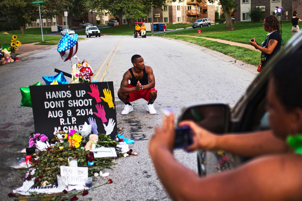 A nearby resident puts his hands together in prayer at a makeshift memorial near the site where unarmed teen Michael Brown was killed in Ferguson, Missouri, Aug. 22, 2014.