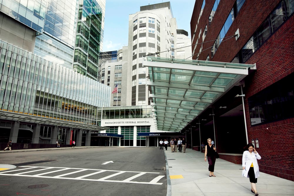 In this July 2, 2012 photo people walk near the entrance of Massachusetts General Hospital in Boston, Mass. (Photo by Steven Senne/AP)