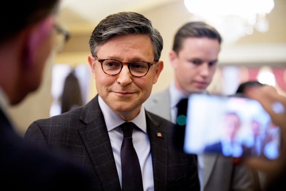 Speaker of the House Mike Johnson speaks with reporters filming him on their phones.
