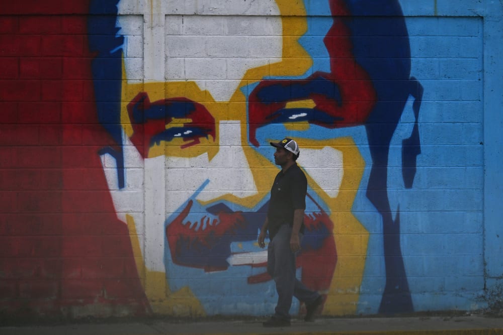 A man walks past a graffiti depicting Venezuelan President Nicolas Maduro in Caracas on January 3, 2026.