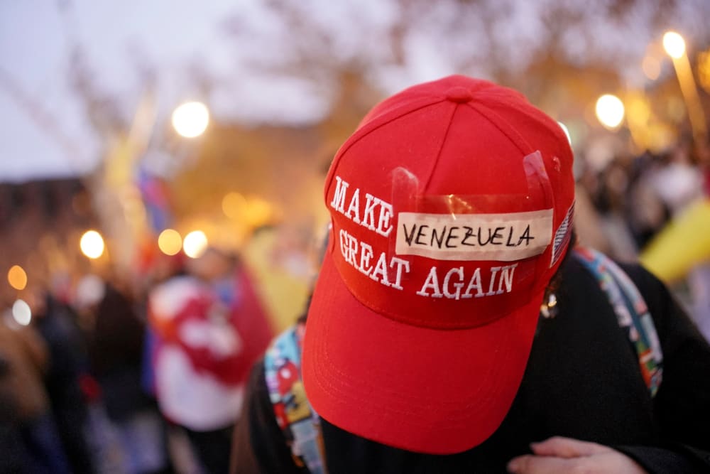 A red MAGA cap with the word "Venezuela" taped over "America"