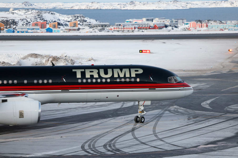 A plane with "TRUMP" written on the side sits on a snowy tarmac.