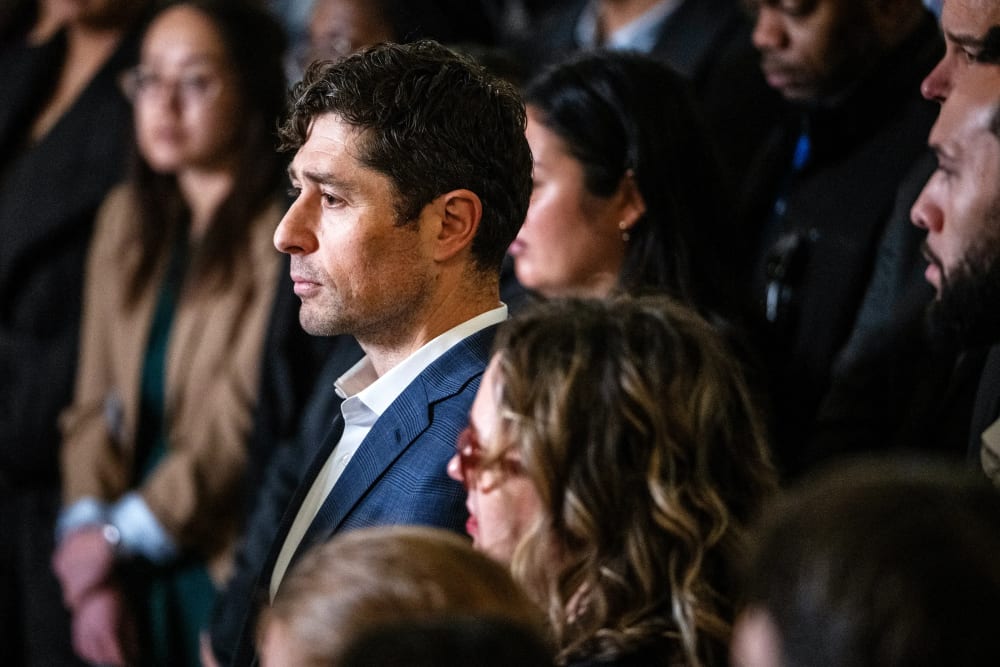 Minneapolis Mayor Frey stands in the middle of a big crowd. He is seen from the left side.