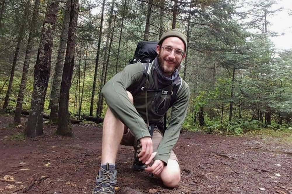 A selfie of a man backpacking in the woods