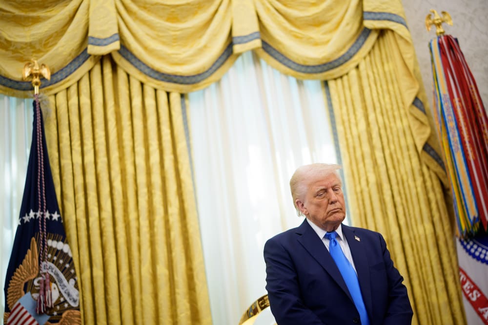 Donald Trump looking down in the Oval Office.