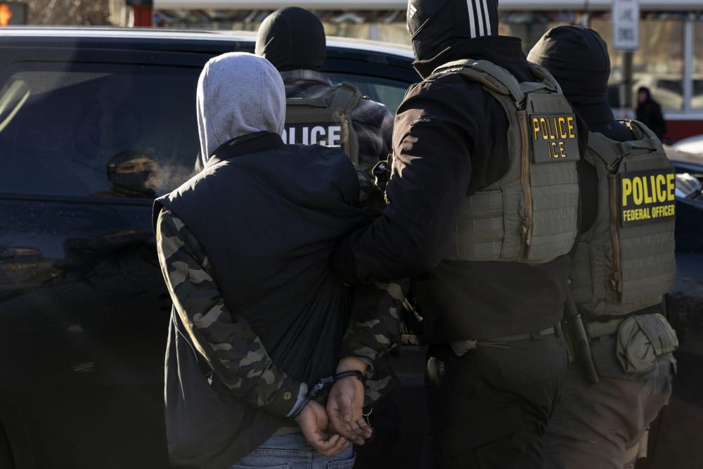 A Federal Agent arrest a man after stopping and questioning him in the street during an Immigration Enforcement Operation on Jan. 14, 2026 in Minneapolis.
