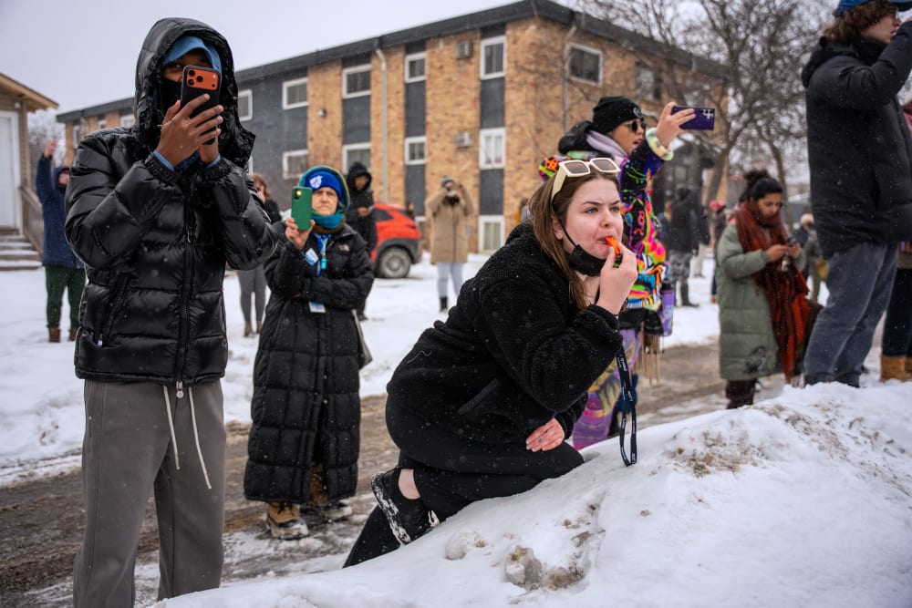 People use their phones to record and blow whistles in the snow.