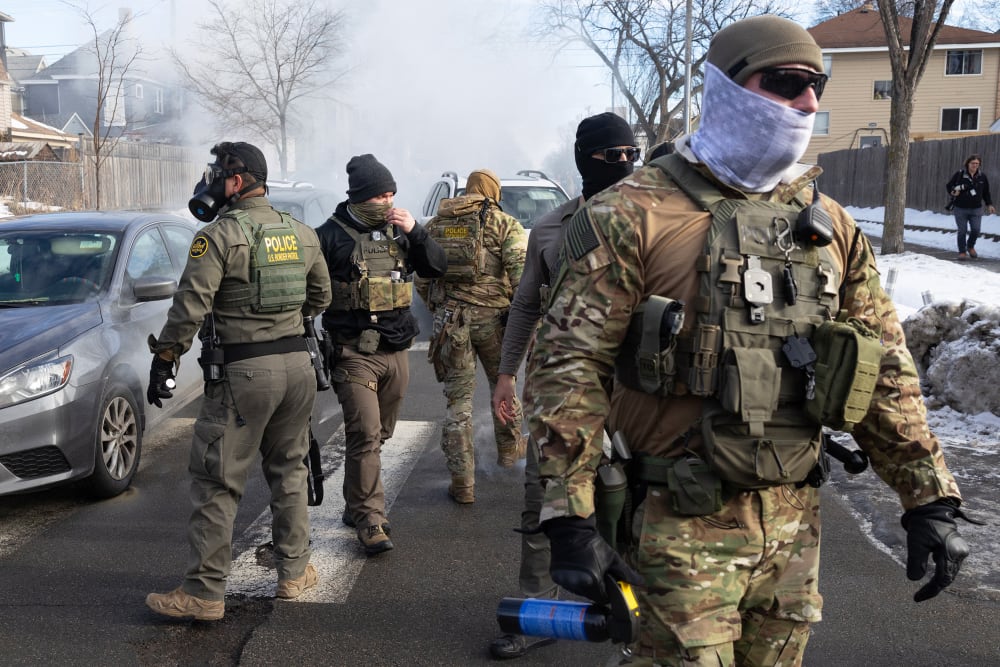Federal agents walk in the street.
