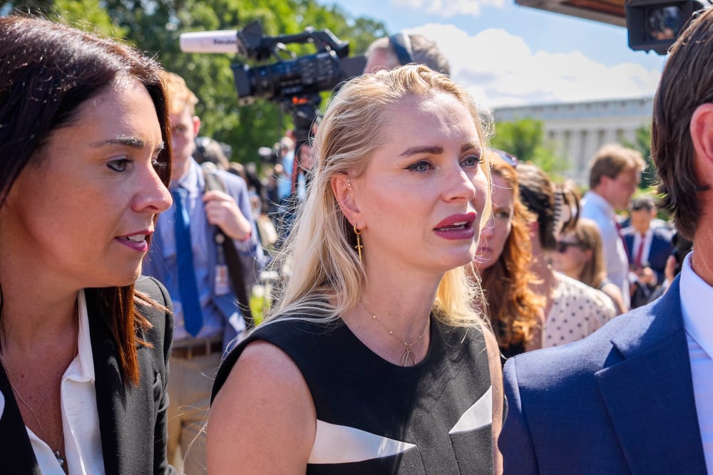 Anouska De Georgiou walks amongst her lawyers as she is crying.