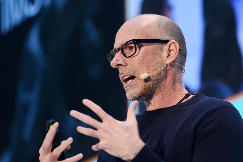 Scott Galloway, with a headset microphone, gestures with his hands.