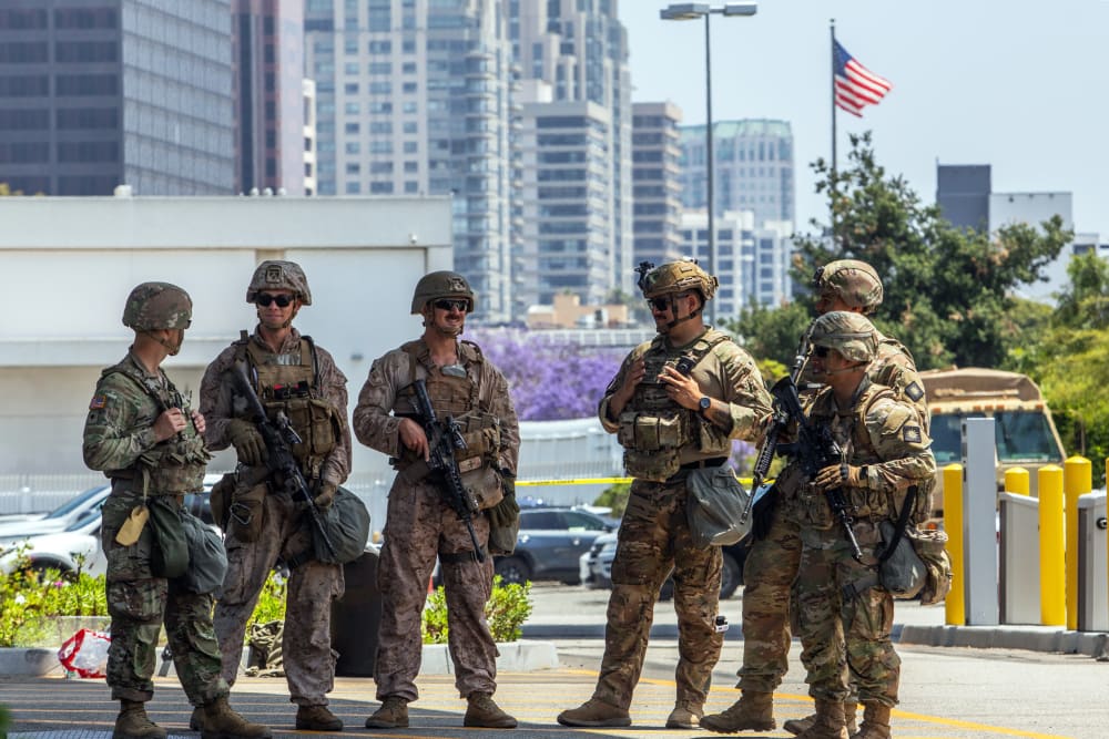 Two U.S. Marines (2nd, 3rd left) stand with California National Guard service members on June 13, 2025 in Los Angeles.
