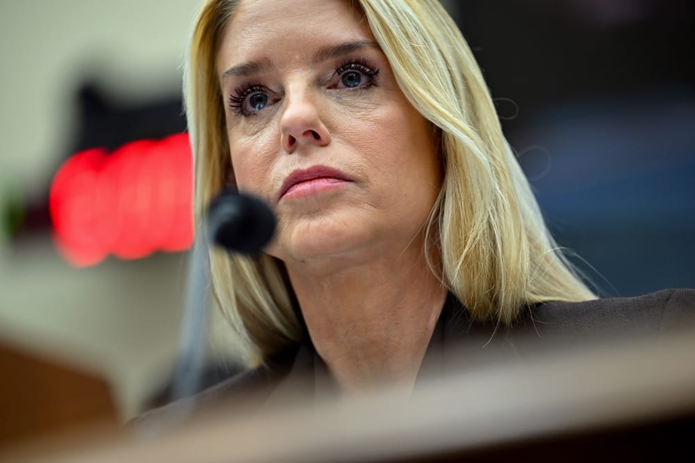 A close up of Pam Bondi behind a microphone.