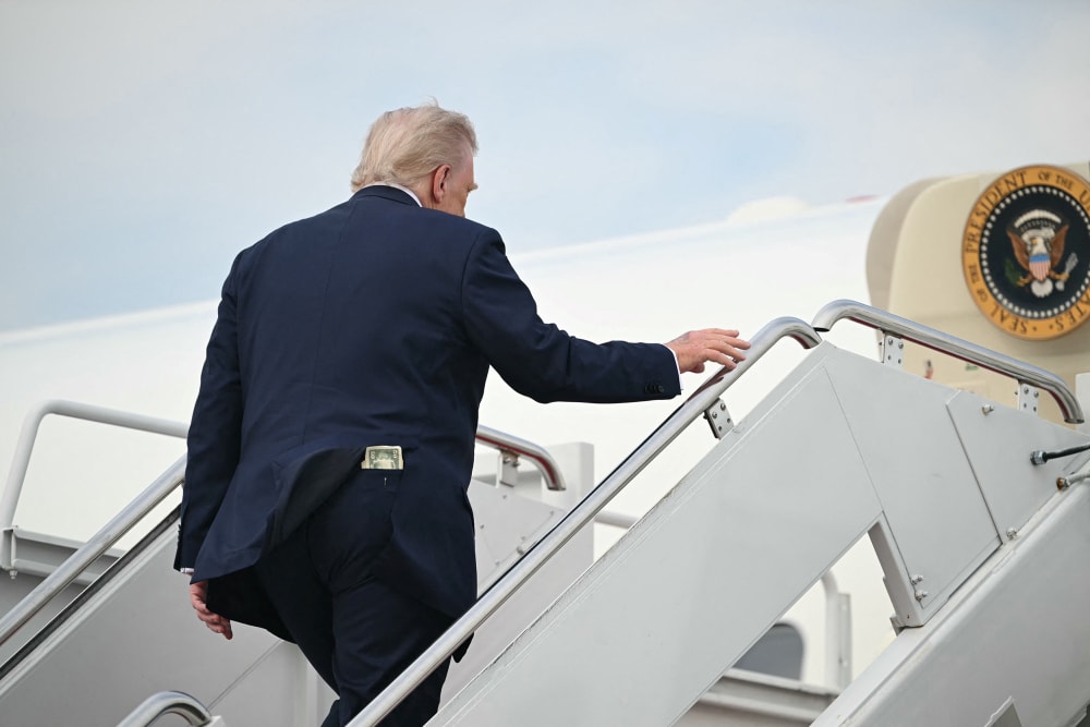 A fifty-dollar bill is seen in President Donald Trump's back pocket as he boards Air Force One.