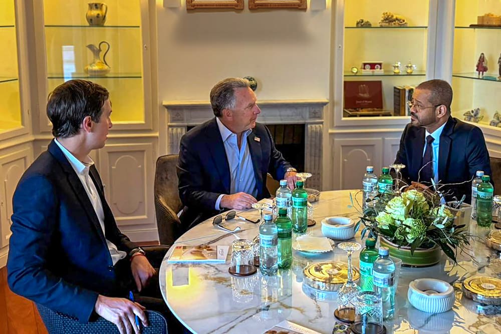 Jared Kushner, Steve Witkoff and Badr Albusaidi sit around a table as they talk.