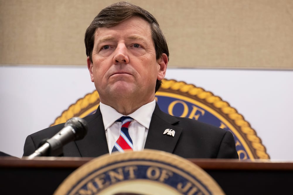 Ed Martin behind a podium with a microphone.