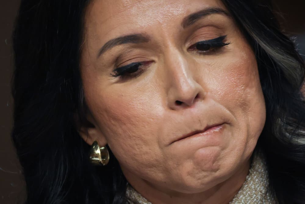 A close up of Tulsi Gabbard as she bites her lip.