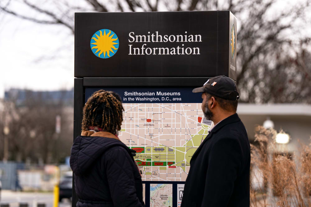 Two people look at a permanent map titled "Smithsonian Museums in the Washington, D.C., area."