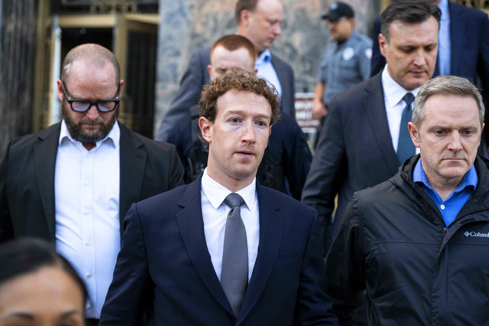 Mark Zuckerberg surrounded by others.