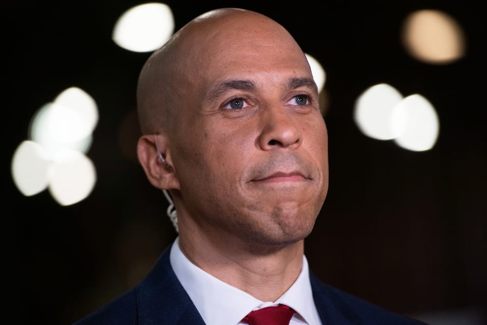 A close up of Cory Booker smiling subtly.