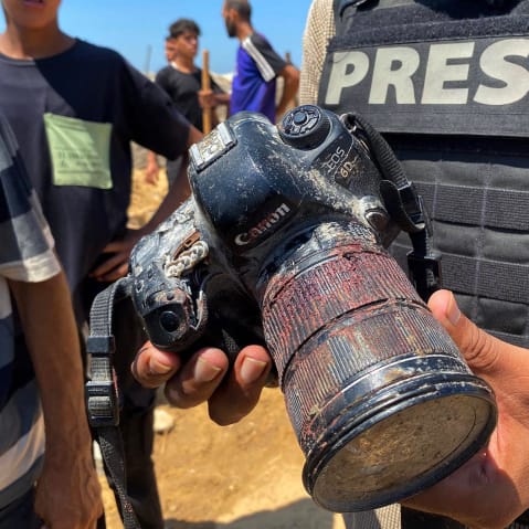 A journalist holds the blood-covered camera belonging to Palestinian photojournalist Mariam Dagga