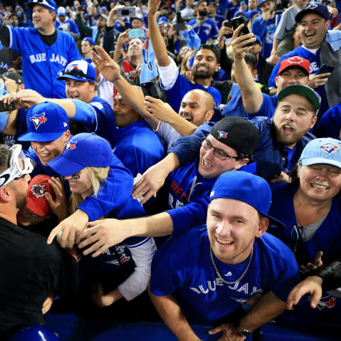 Marco Estrada #25 of the Toronto Blue Jays is swarmed by fans in Toronto, Canada.