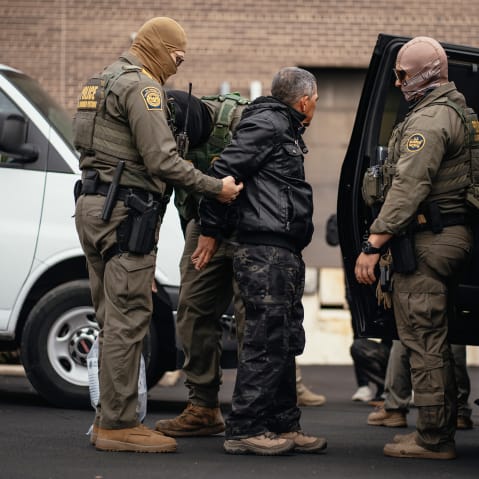 Immigration and Customs Enforcement agents take people they detained earlier to a parking lot before transferring them to an ICE facility in Chicago.