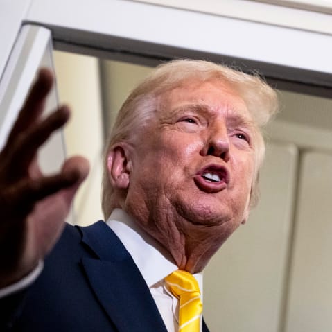 U.S. President Donald Trump speaks to members of press aboard Air Force One.