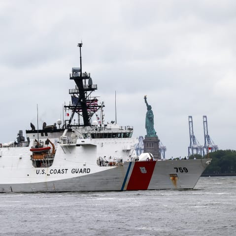 A Coast Guard ship sails past the Statue of Liberty.