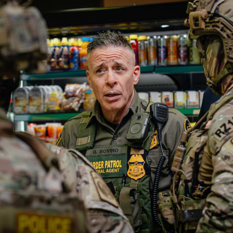 Gregory Bovino talks with other federal agents.