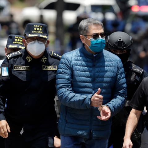 Former President of Honduras Juan Orlando Hernandez is escorted by the police to be extradited to U.S.to face charges of taking bribes from drug traffickers at Honduran National Directorate of Special Forces on April 21, 2022, in Tegucigalpa, Honduras.