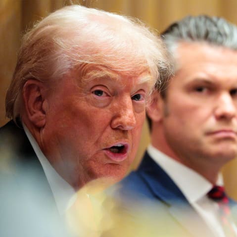 U.S. Secretary of War Pete Hegseth (R) looks on as U.S. President Donald Trump speaks during a meeting of his Cabinet.