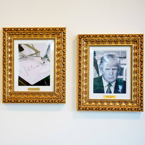 Framed portraits of President Donald Trump flank an image of former President Joe Biden's signature and an autopen along "The Presidential Walk of Fame" at the White House.